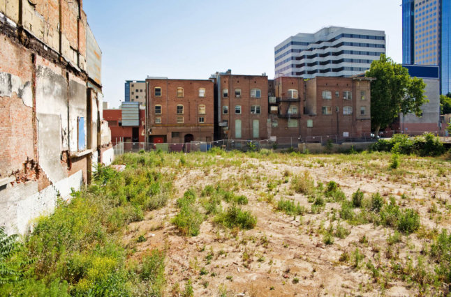 Decaying buildings and patchy grass.