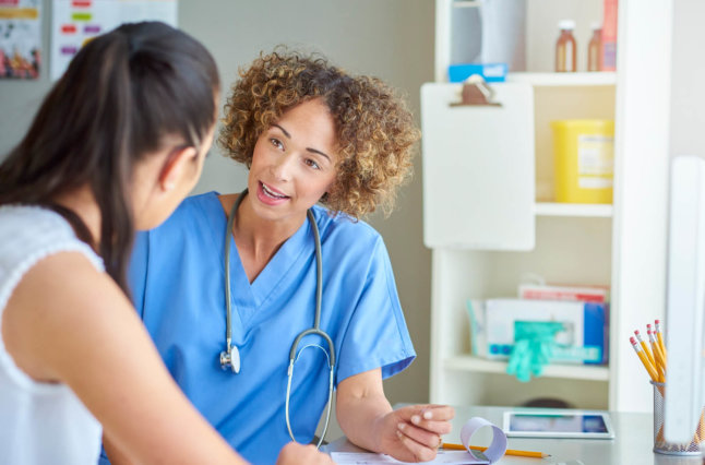 Woman doctor talking to woman patient.