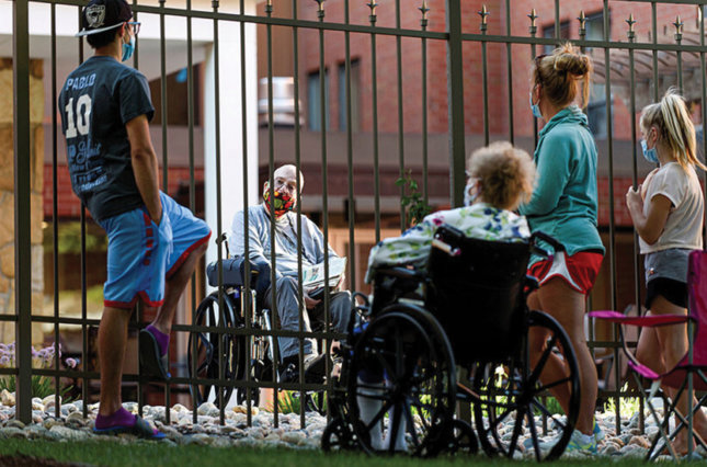 Family and friends of Myron Wagner visit him outside Bethany Retirement Living as they practice social distancing during the COVID-19 pandemic in Fargo, ND