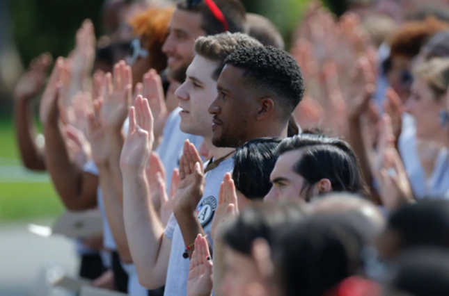 AmeriCorps volunteers take a pledge as then-President Barack Obama and former president Bill Clinton mark the 20th anniversary of AmeriCorps on the South Lawn of the White House, Sept. 12, 2014