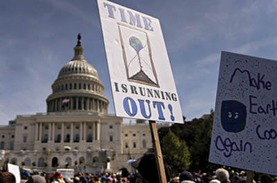 Signs held by climate change protesters in front of the U.S. Capitol building