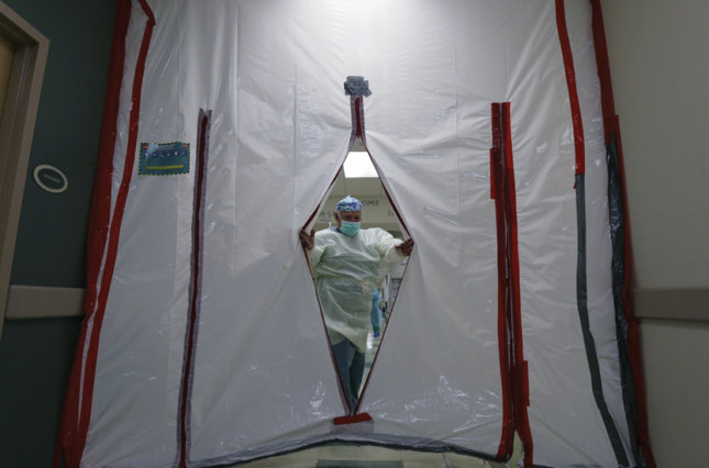 Dr. Efraim Vela slips through a makeshift door to an area for pregnant women and new moms with COVID-19 at DHR Health, Wednesday, July 29, 2020, in McAllen, Texas.