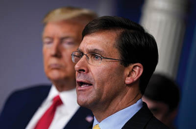 Defense Secretary Mark T. Esper speaks as President Trump listens during a news briefing with the coronavirus task force March 18 at the White House.