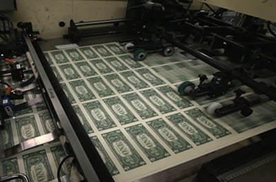 Sheets of $1 bills run through the printing press in 2015 at the U.S. Bureau of Engraving and Printing in Washington, D.C.