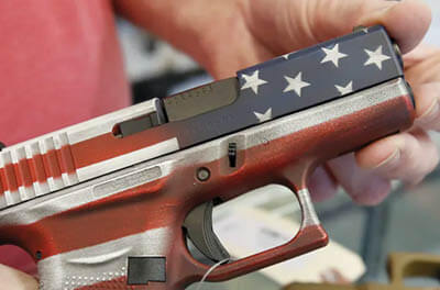 Man holding a handgun painted like an American flag