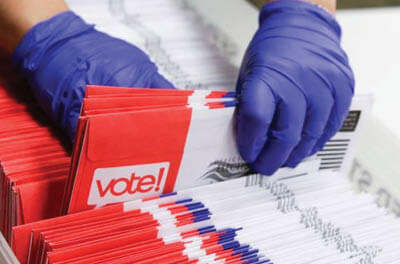 USPS worker processing mail ballots