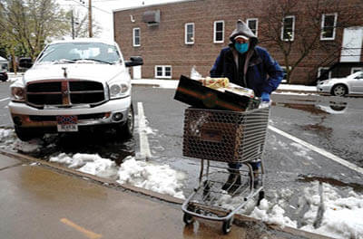 Volunteer Wally Rositzki maneuvers a shopping cart filled with food next to a pickup truck with a Confederate flag plate outside the West CAP Food Pantry in Boyceville, Wisconsin, U.S., October 22, 2020. Picture taken October 22, 2020