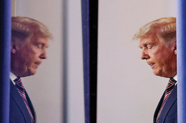 Donald Trump and his reflected image as he arrives to speak about the 2020 election results as he arrives to speak at the press briefing room of the White House on November 5, 2020