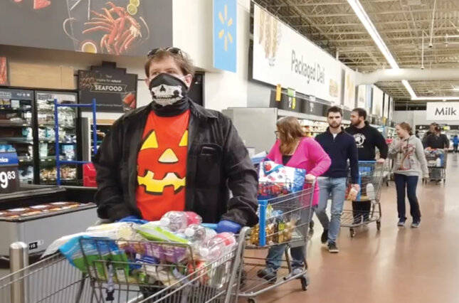 Shoppers in a grocery store - some wearing masks, some not.