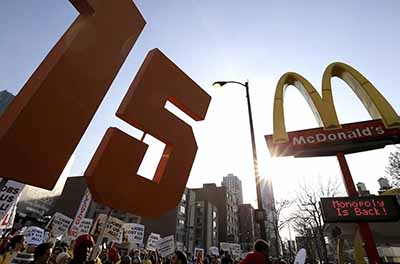 Demonstrators march past a McDonald’s restaurant during a protest calling for a $15-an-hour nationwide minimum wage in Chicago, Ill.