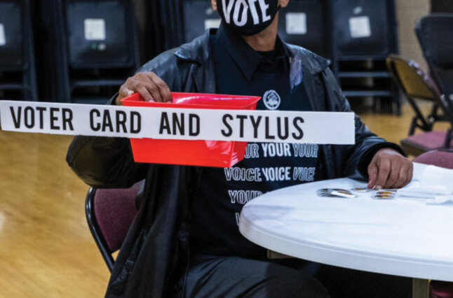 Voter volunteer collects items to be sanitized