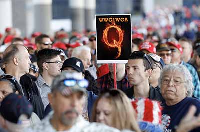 A man holds a QAnon sign with the group's abbreviation of their rallying cry "Where we go one, we go all" at a Trump campaign rally in Las Vegas, Nevada, on Feb. 21, 2020.