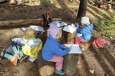 Students participate in class outside at the Woodland Pond School, a private school located near Bangor, Maine.