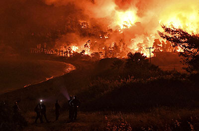 Fire burns during a wildfire near the village of Schinos, Greece, on May 19, 2021. | Valerie Gache/AP Photo