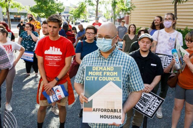 Housing rights advocates hold signs and listen to speakers at a rally for affordable housing in Columbus, Ohio, on June 30, 2021