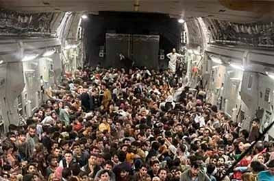 Hundreds of Afghan citizens, fleeing their home country, await takeoff after packing inside a U.S. Air Force C-17 transport at Hamid Karzai International Airport in Afghanistan.