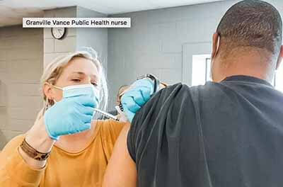 Caroline Brewer, a nurse with Granville Vance Public Health in North Carolina, administers a COVID-19 vaccine. A new federal survey of public health workers found that more than half reported having symptoms of serious mental health conditions as a result of their work on the pandemic.