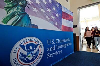 Three women immigrants entering a U.S. Citizenship and Immigration Services office