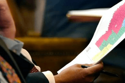 Graphic image of State Sen. Joseph Thomas, D-Yazoo City, holds a copy of the proposed congressional redistricting map during debate over redistricting at the Mississippi State Capitol in Jackson, Jan. 12, 2022.