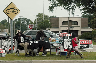 A woman outside a Georgia polling site offers to help voters who cannot read.