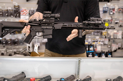 A gun store employee displays an AR15 assault rifle