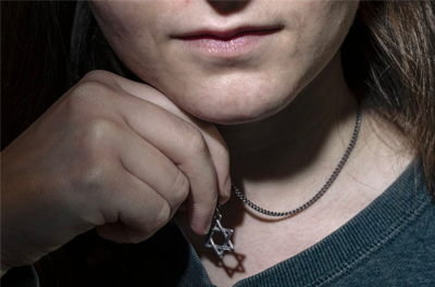 Woman hiding star of David necklace under her shirt