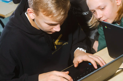 Students gather around a laptop in Finland