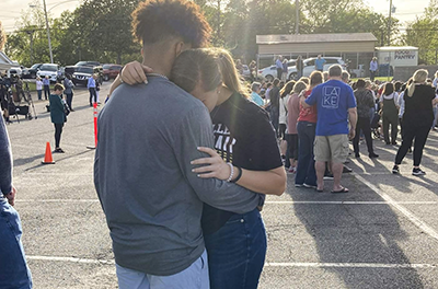 Two teens embrace at a prayer vigil Sunday outside First Baptist Church in Dadeville, Ala. Several people were killed and over two dozen were injured in a shooting at a teen birthday party in the town.