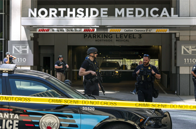 Law enforcement officers stand outside Northside Hospital in Atlanta after a man opened fire in the waiting room killing one and wounding four.