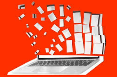 A laptop with many small white papers flying out of the screen against a bright orange background.
